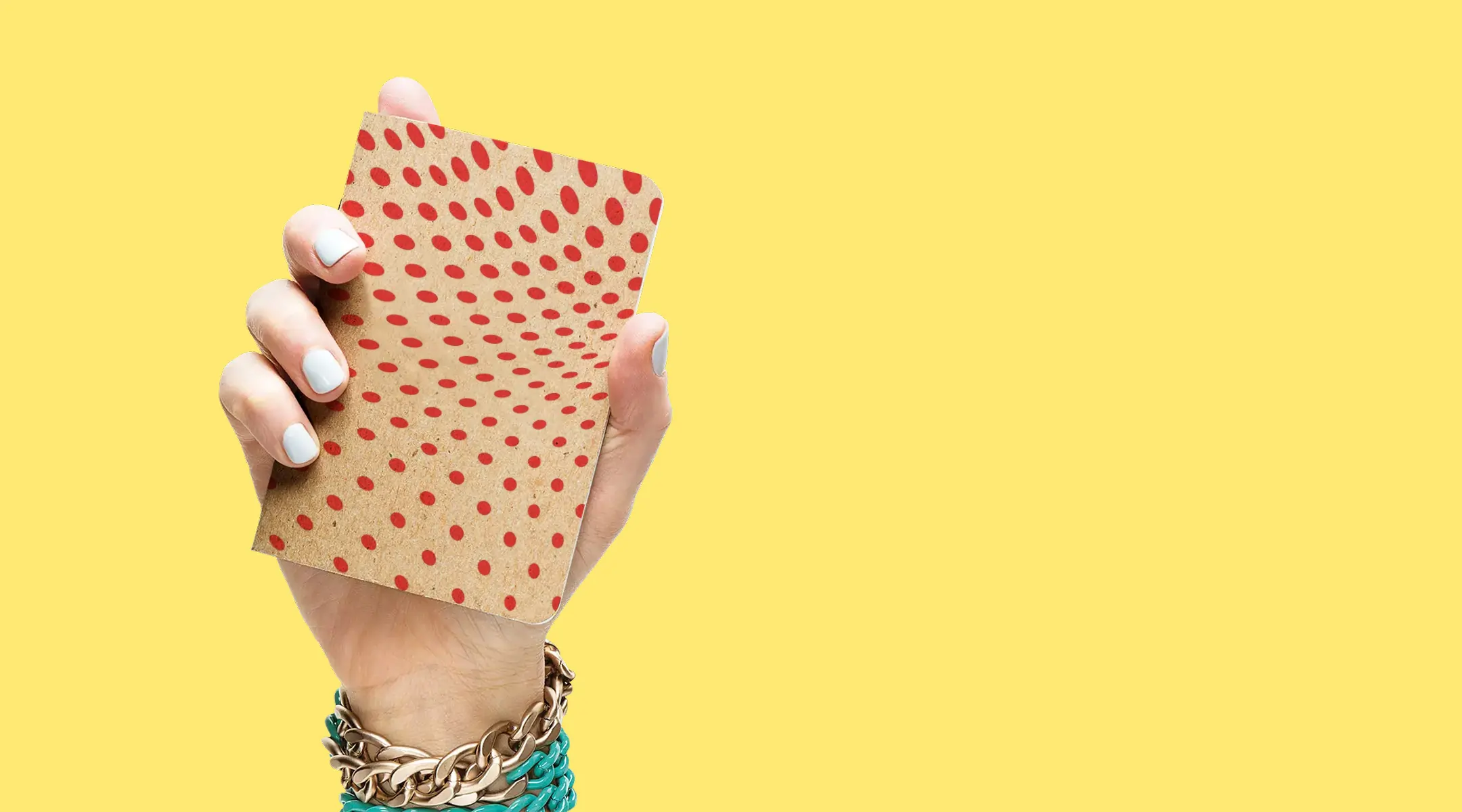 A womans hand victoriously holds up a beautiful custom printed notebook by Scout Books against a solid yellow color background.
