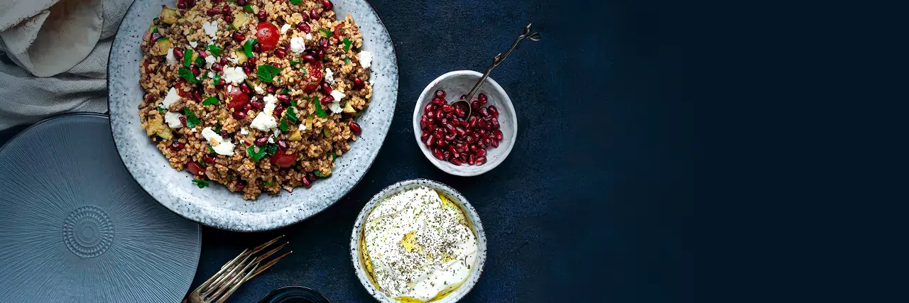 An overhead view of some delicious halal food from It's Halal meal delivery service on a navy blue table.