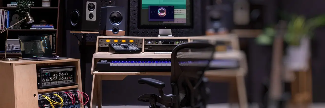 A beautiful audio production desk from Output DEFI in a modern music studio with advanced audio equipment.